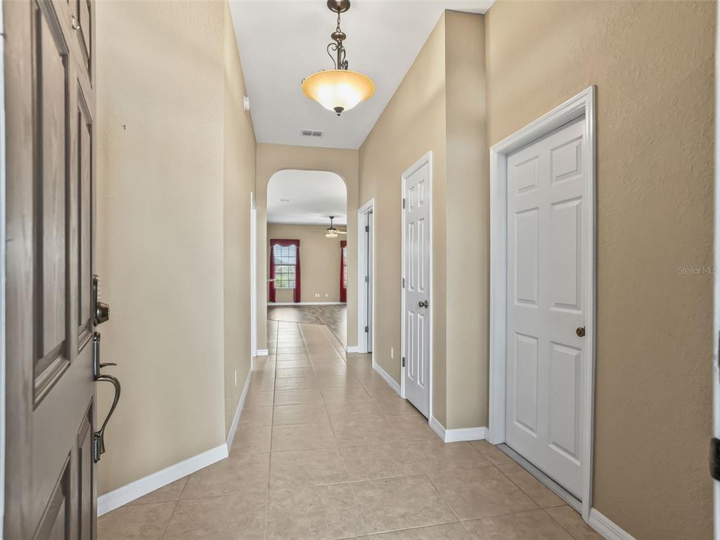 16896 South East 110th Court Road Summerfield, FL 34491 - Photo 6 of 61 a view of a hallway with wooden floor and chandelier