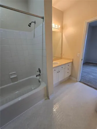 a spacious bathroom with a tub sink and mirror
