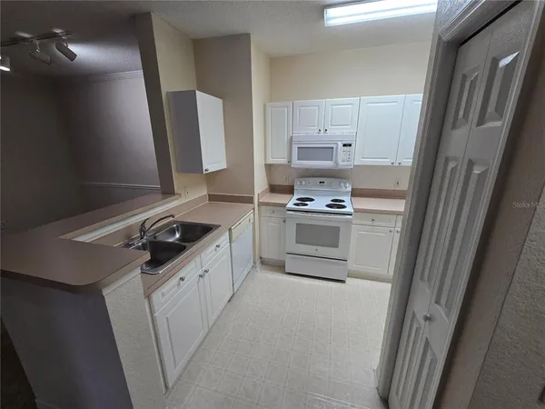 a kitchen with a sink stove and refrigerator