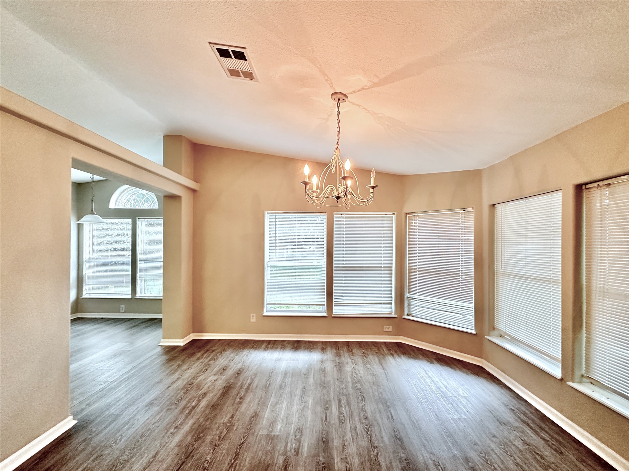 202 Main Street Fresno, TX 77545 - Photo 12 of 26 an empty room with wooden floor and windows