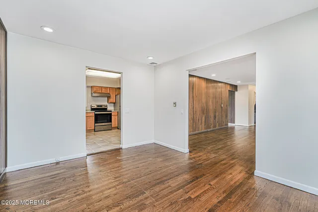 a view of a hallway with wooden floor and closet