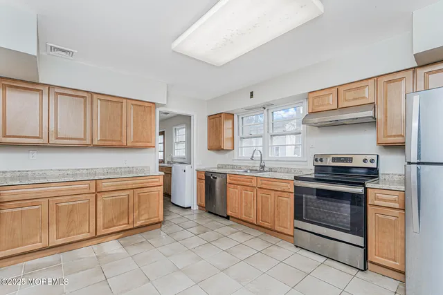 a kitchen with stainless steel appliances granite countertop a stove sink and cabinets