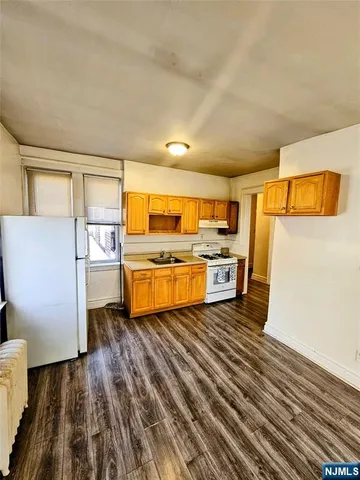 a kitchen with stainless steel appliances a refrigerator and wooden cabinets
