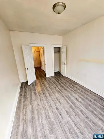 an empty room with wooden floor and mirror