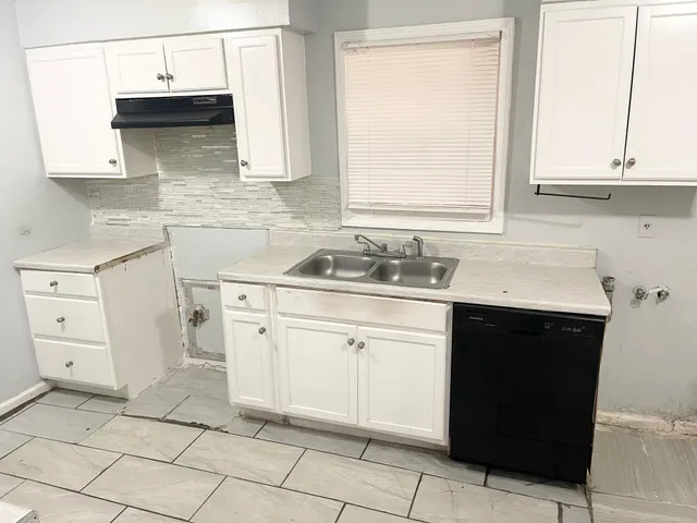 a kitchen with granite countertop white cabinets and black appliances