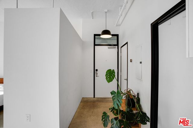 a vase of flowers sitting on a floor in front of a window