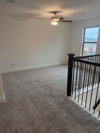 a view of a hallway with chandelier fan