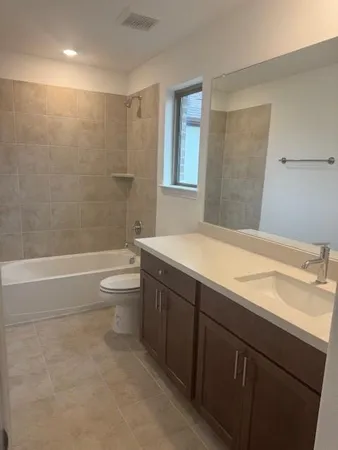 a bathroom with a granite countertop sink a toilet and shower