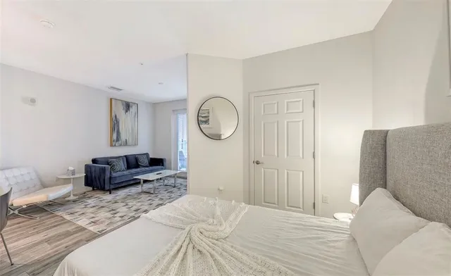 a bedroom with a bed a mirror and a table