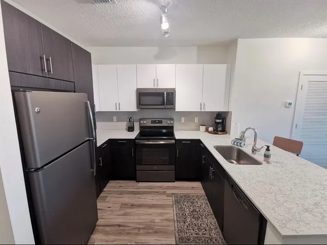 a kitchen with a refrigerator sink and wooden cabinets