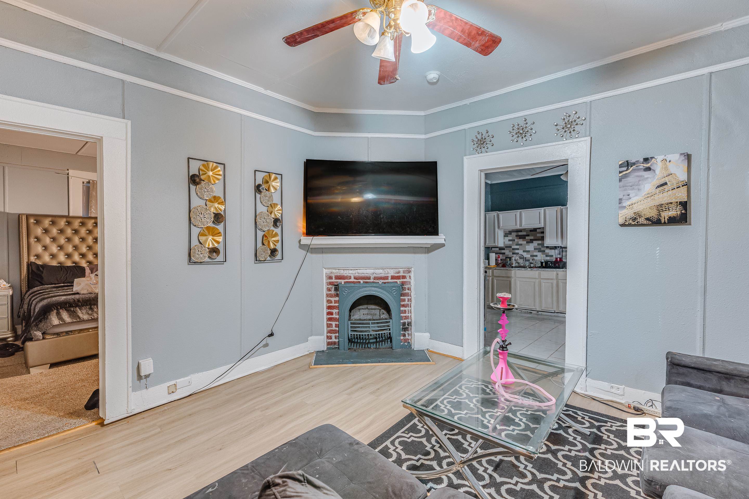 14 Southern Street Mobile, AL 36611 - Photo 4 of 26 Living room with wood-type flooring, ceiling fan, crown molding, and a fireplace