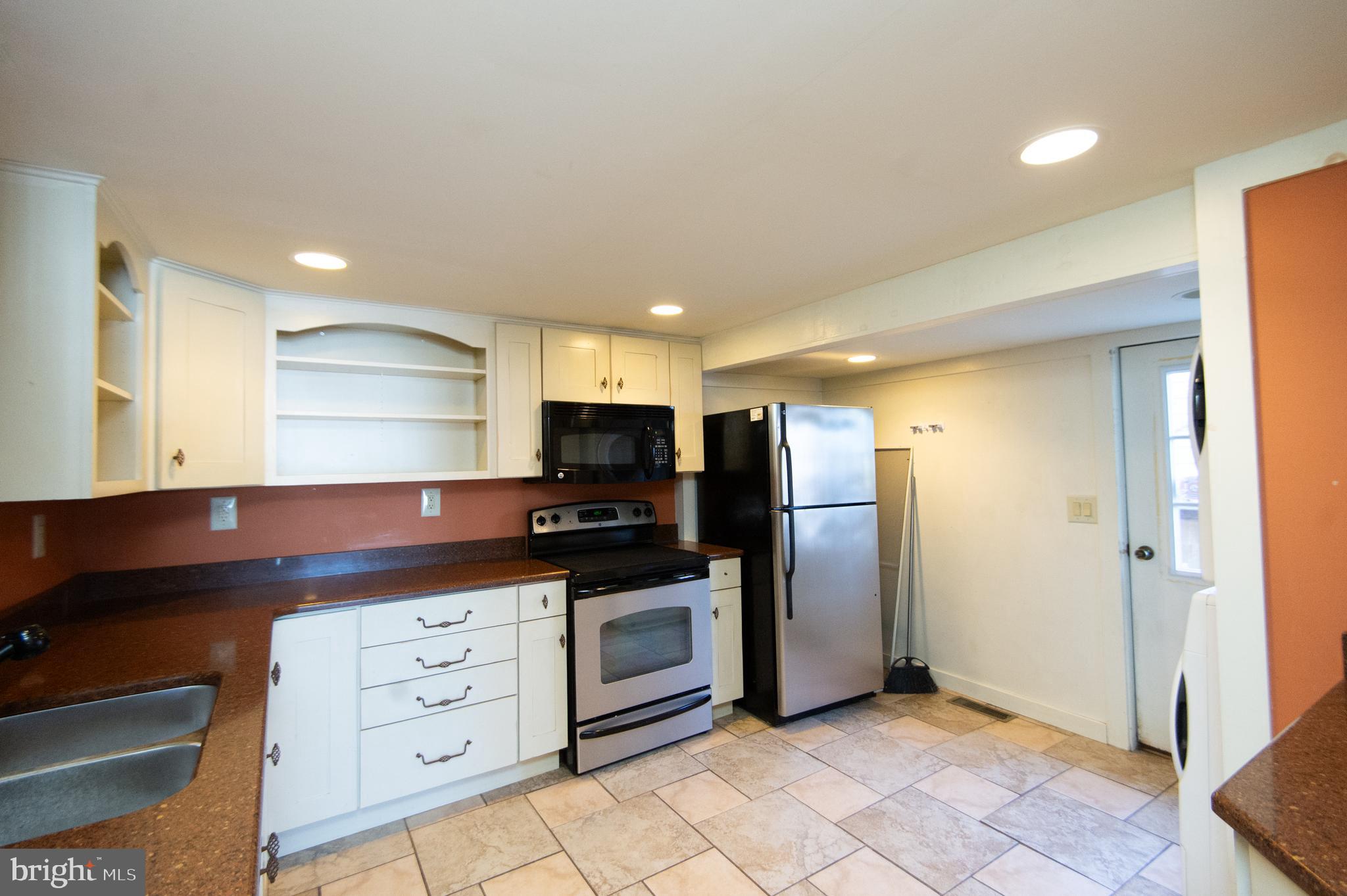102 Hayward Street Cambridge, MD 21613 - Photo 11 of 35 a kitchen with stainless steel appliances a refrigerator and a stove top oven