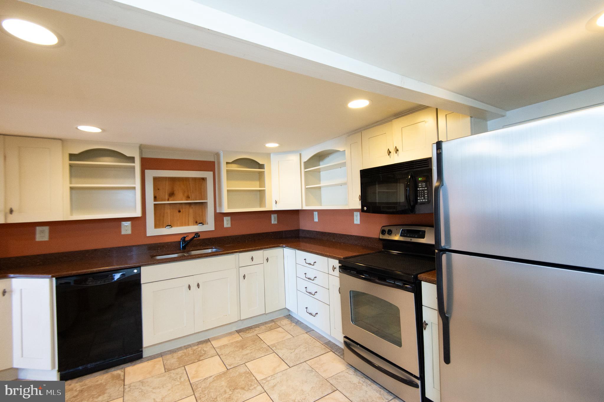 102 Hayward Street Cambridge, MD 21613 - Photo 12 of 35 a kitchen with granite countertop a sink stainless steel appliances and cabinets