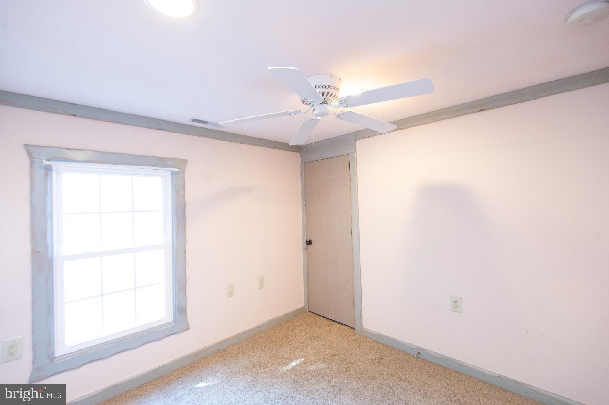 102 Hayward Street Cambridge, MD 21613 - Photo 19 of 35 an empty room with a window and a fan