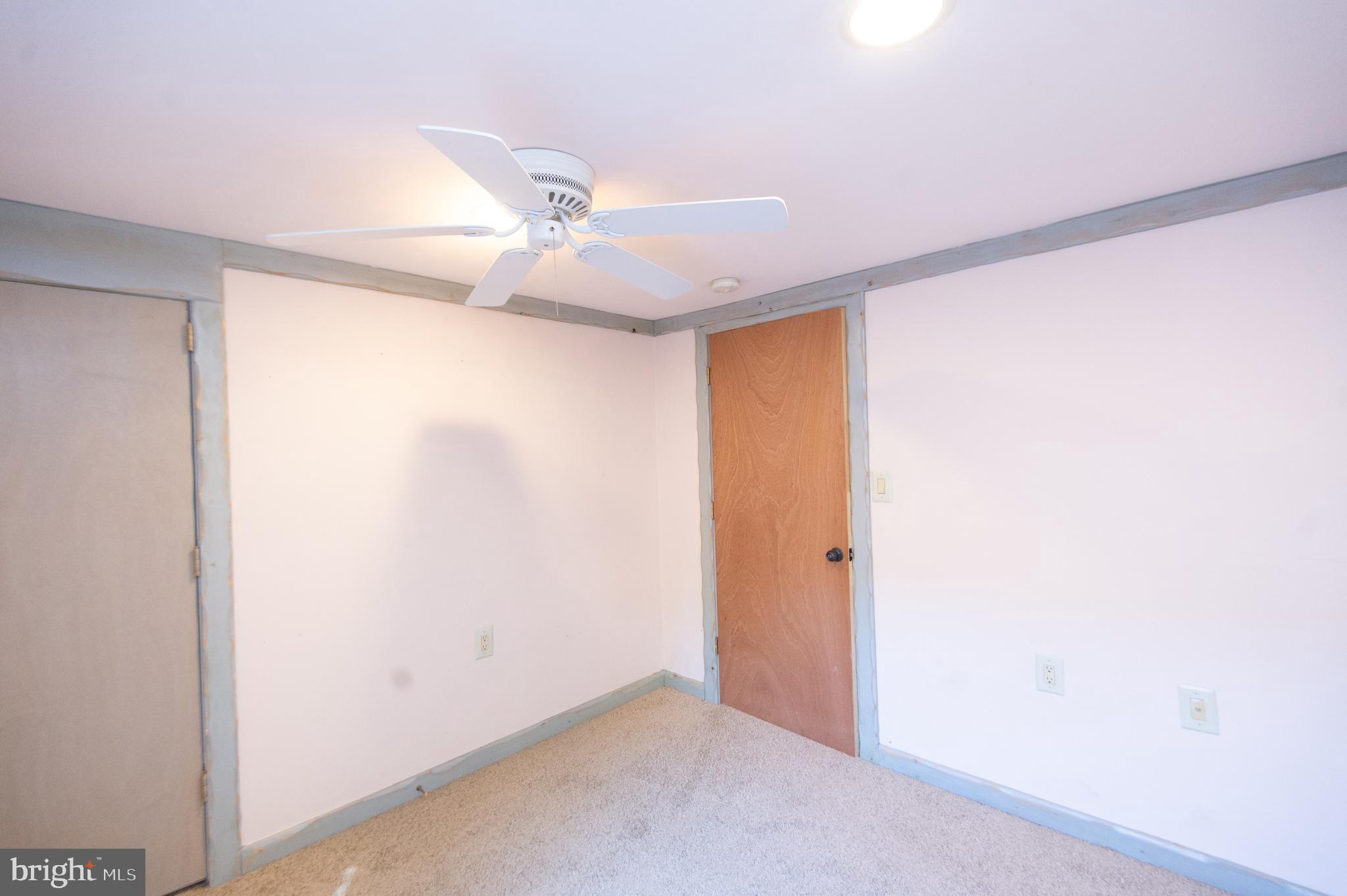 102 Hayward Street Cambridge, MD 21613 - Photo 20 of 35 an empty room with a ceiling fan and a window