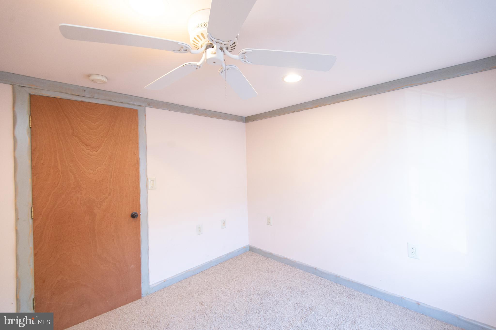 102 Hayward Street Cambridge, MD 21613 - Photo 21 of 35 an empty room with a ceiling fan and a window