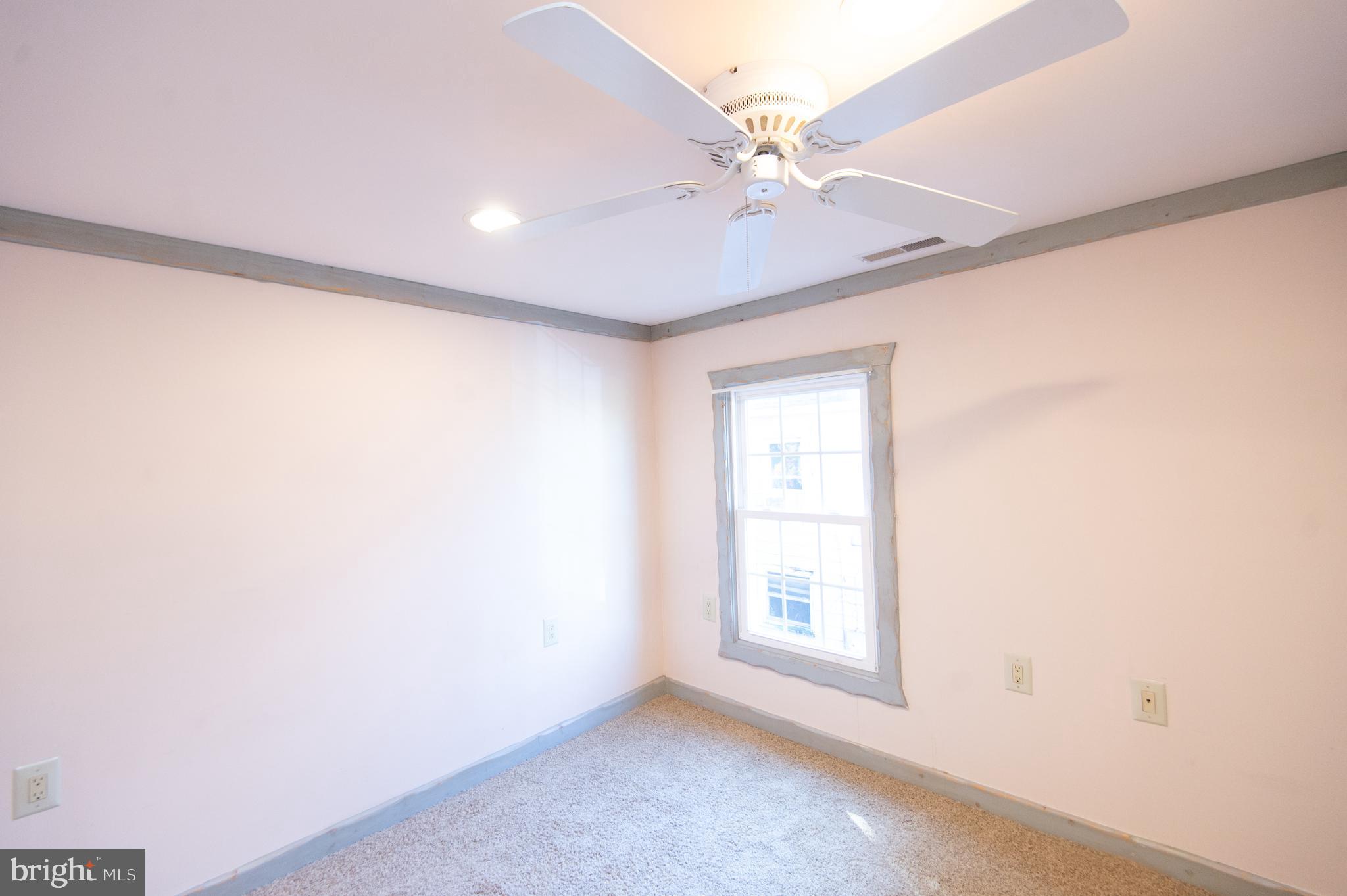 102 Hayward Street Cambridge, MD 21613 - Photo 22 of 35 an empty room with a window and a fan