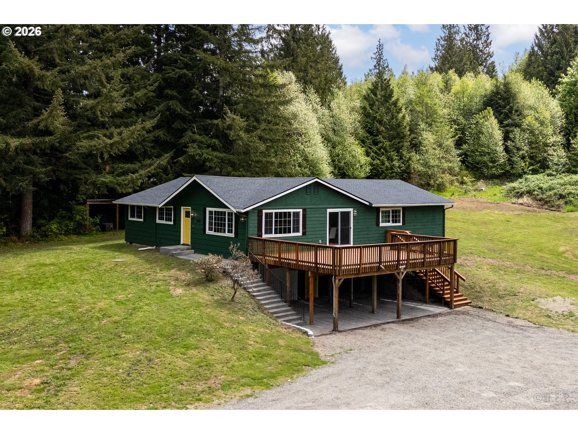29234 Thistle Hill Road Rainier, OR 97048 - Photo 1 of 33 a front view of a house with a wooden deck and a yard
