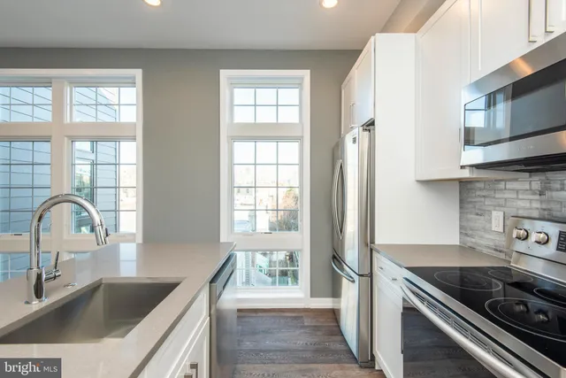 a kitchen with granite countertop a sink and a stove next to a window