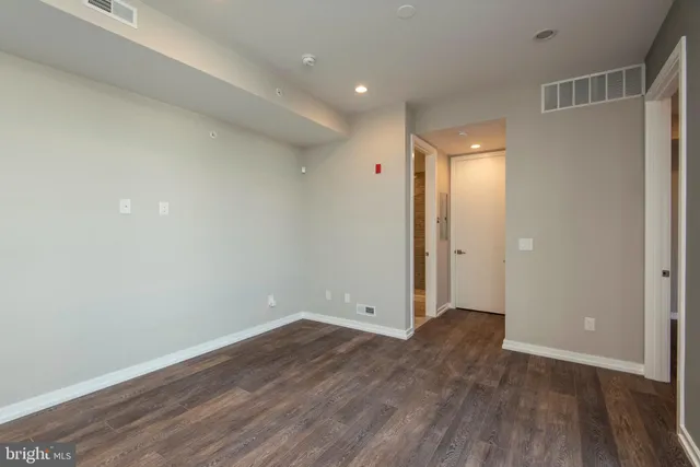 a view of an empty room with wooden floor