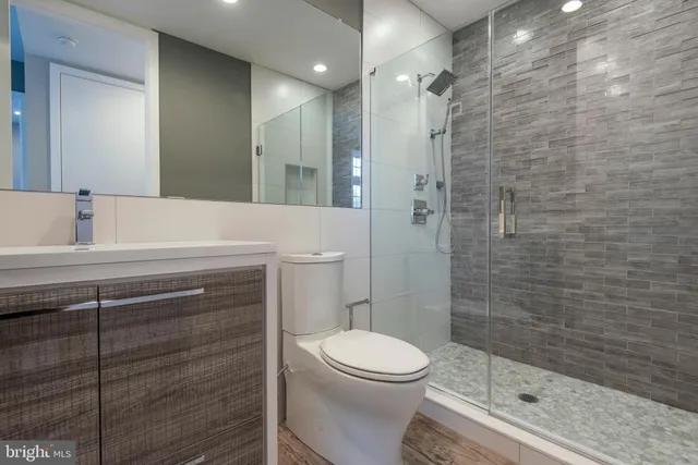 a bathroom with a sink a toilet and shower