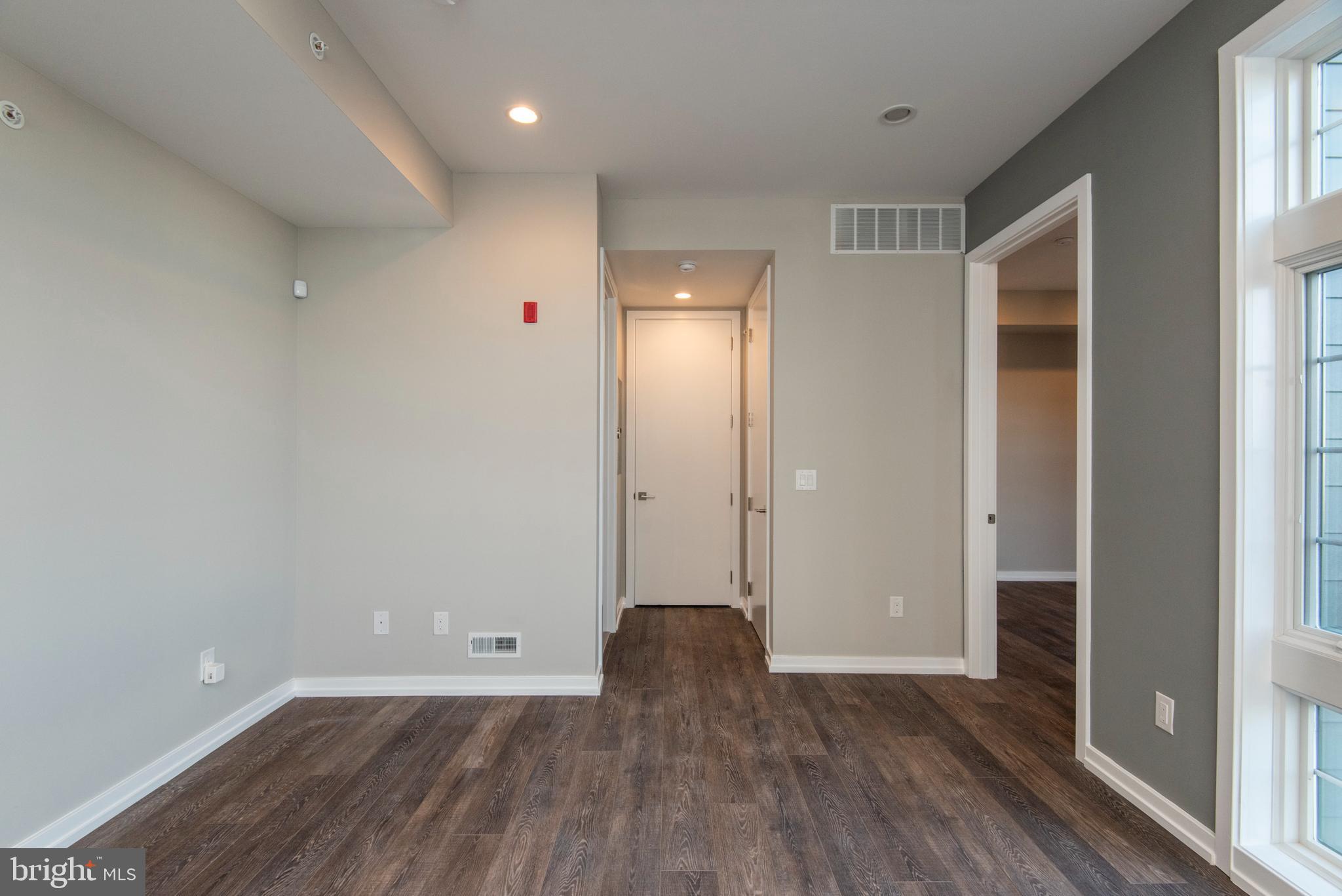 1340 South 13th Street, Unit 3B Philadelphia, PA 19147 - Photo 21 of 31 a view of an empty room with wooden floor and a window