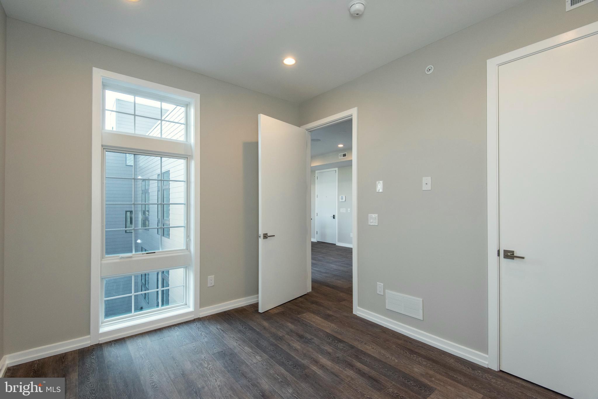 1340 South 13th Street, Unit 3B Philadelphia, PA 19147 - Photo 24 of 31 an empty room with wooden floor and windows