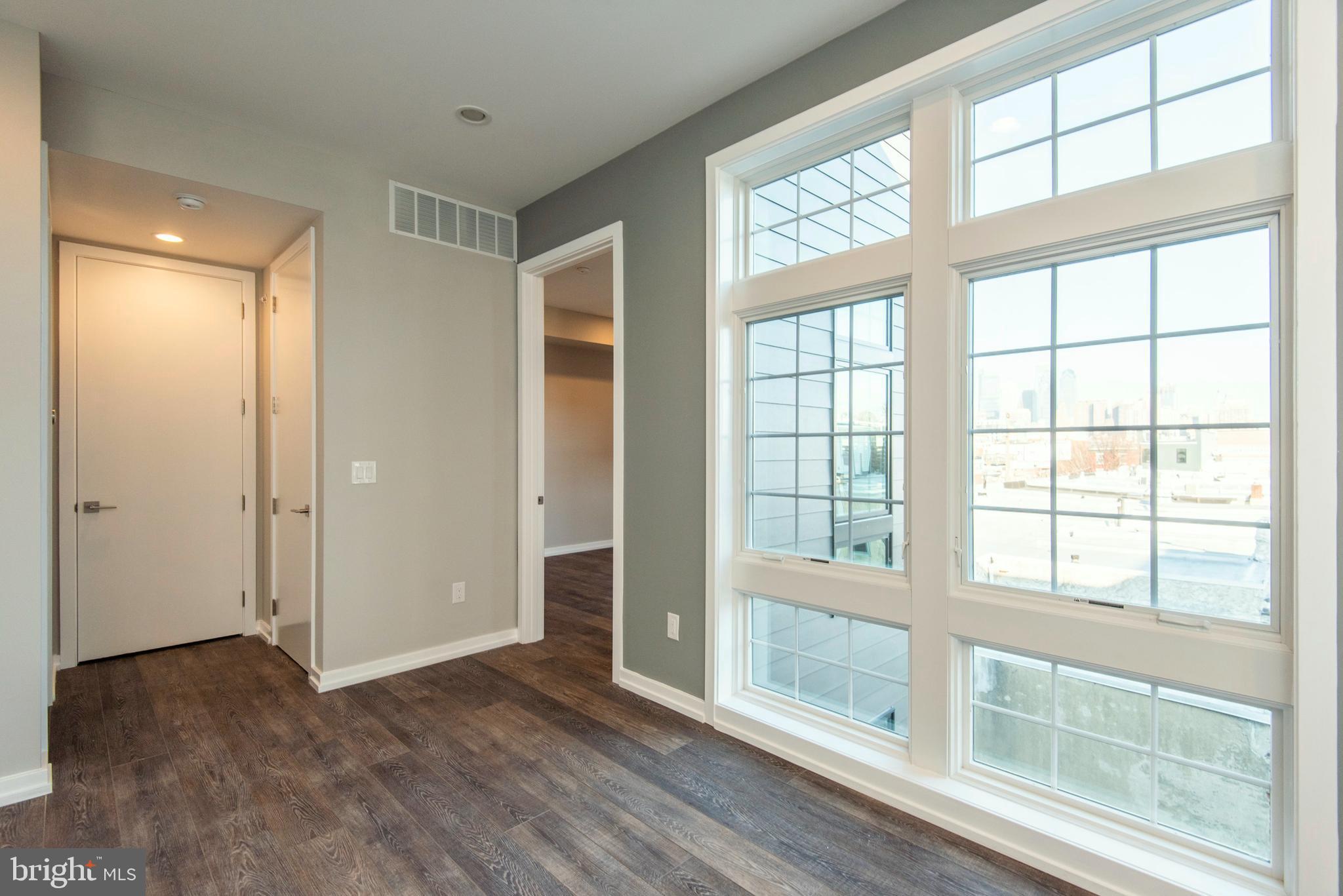 1340 South 13th Street, Unit 3B Philadelphia, PA 19147 - Photo 28 of 31 a view of an empty room with wooden floor and windows