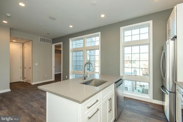 a kitchen with stainless steel appliances granite countertop a sink and a large window