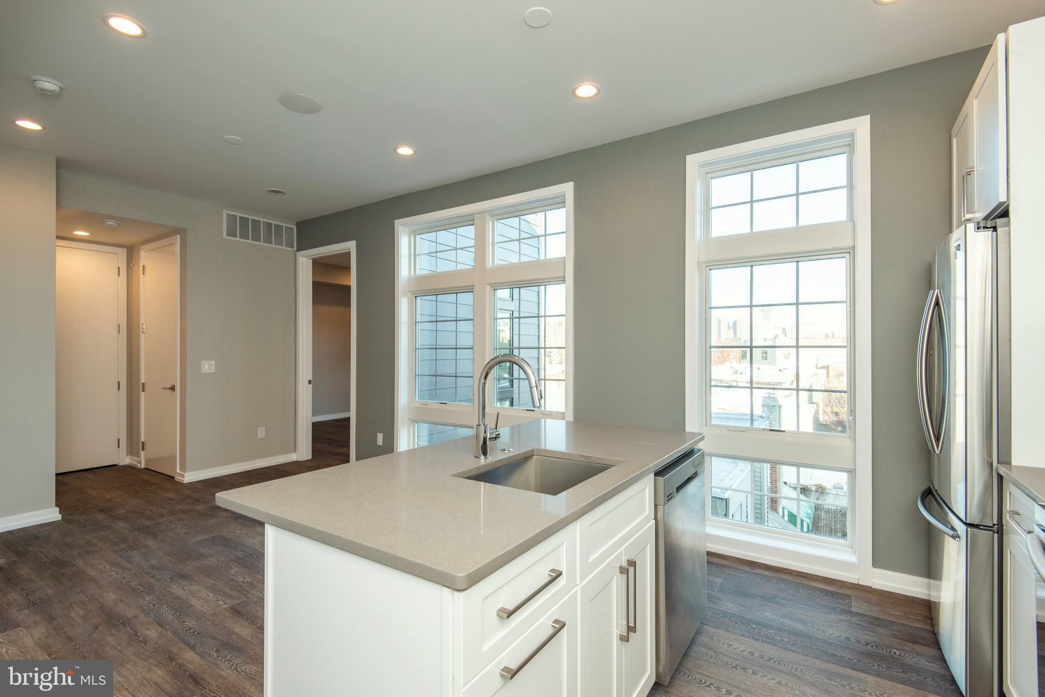 1340 South 13th Street, Unit 3B Philadelphia, PA 19147 - Photo 9 of 31 a kitchen with stainless steel appliances granite countertop a sink and a large window