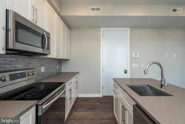 a kitchen with stainless steel appliances granite countertop a sink stove and microwave