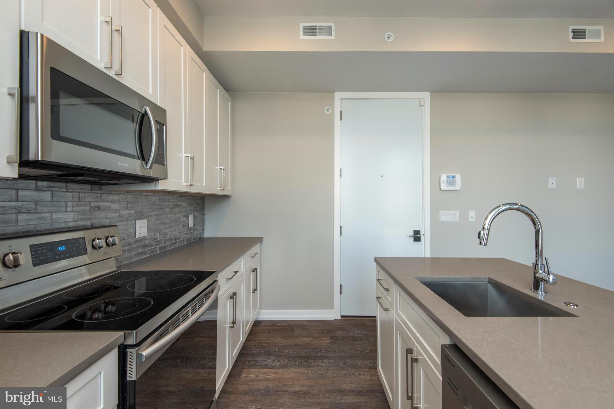 1340 South 13th Street, Unit 3B Philadelphia, PA 19147 - Photo 10 of 31 a kitchen with stainless steel appliances granite countertop a sink stove and microwave
