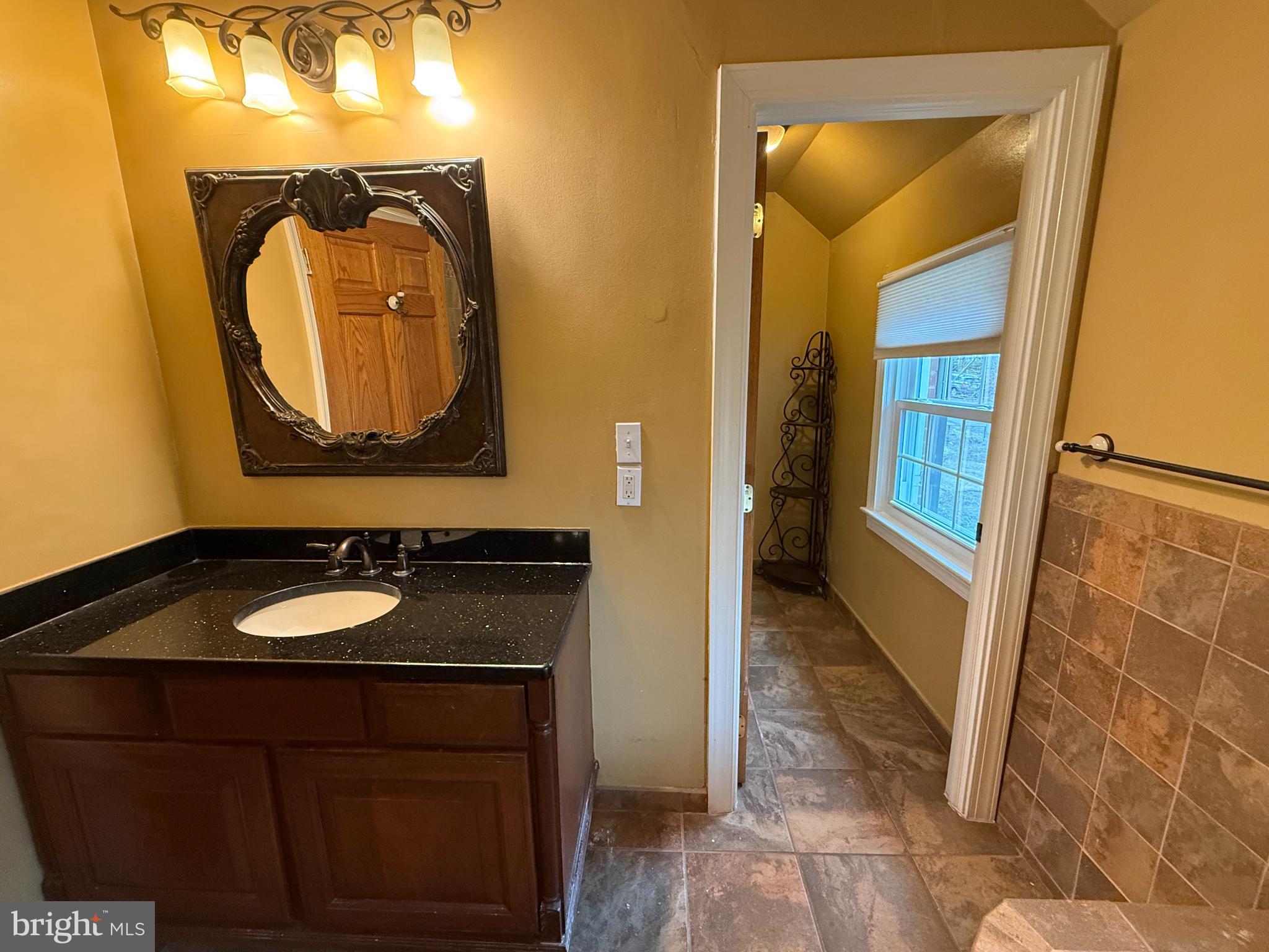 3202 Rolling Road Chevy Chase, MD 20815 - Photo 26 of 43 a bathroom with a sink and a mirror