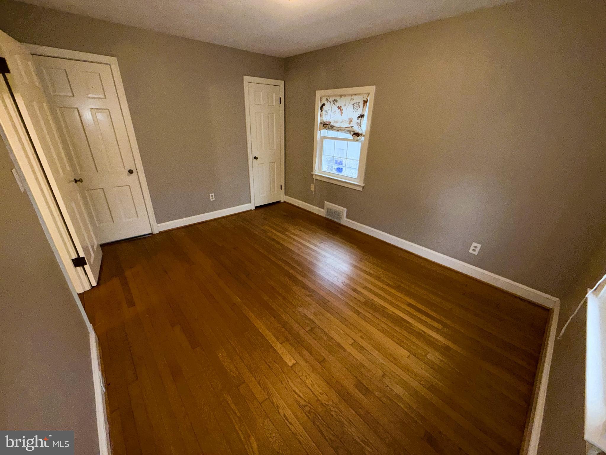 3202 Rolling Road Chevy Chase, MD 20815 - Photo 30 of 43 a view of an empty room with wooden floor and a window