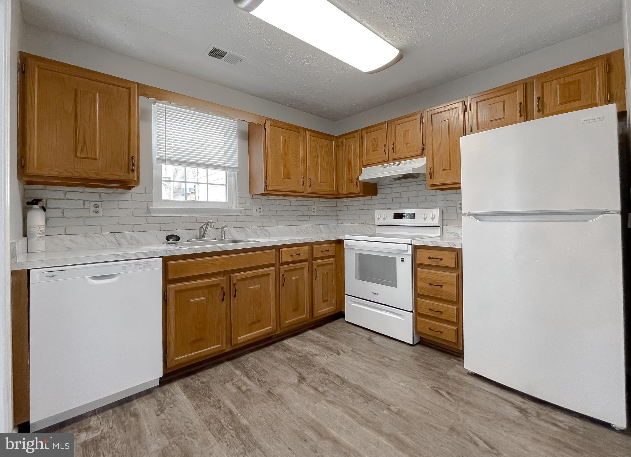 4232 Drake Court Waldorf, MD 20603 - Photo 11 of 25 a kitchen with a white cabinets and white appliances