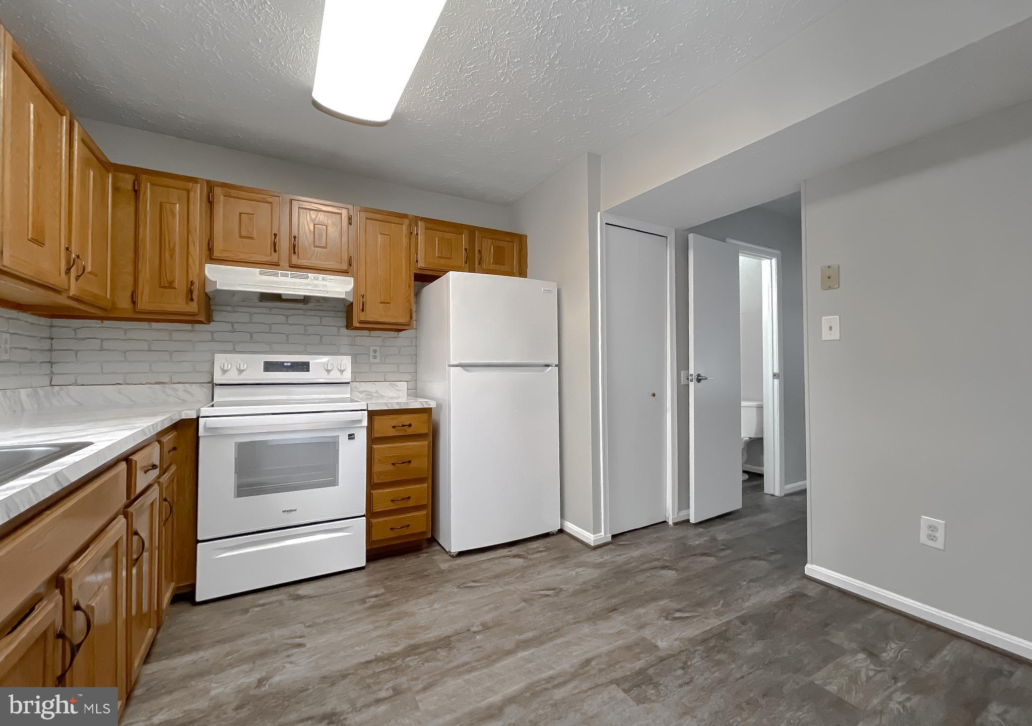 4232 Drake Court Waldorf, MD 20603 - Photo 8 of 25 a kitchen with white cabinets and white appliances