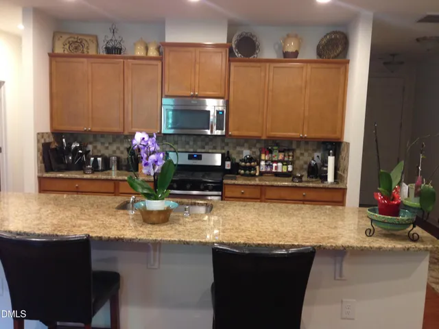 a kitchen with sink a microwave a stove and cabinets
