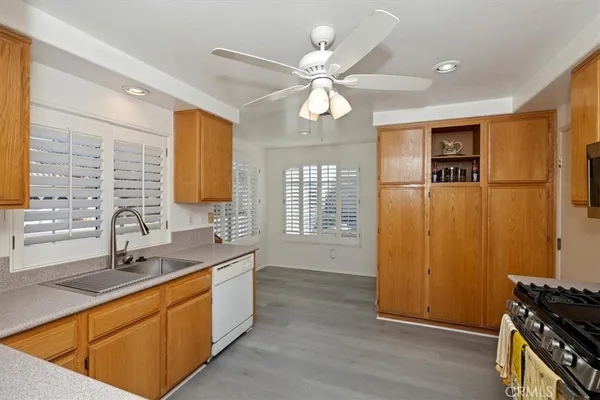 a kitchen with stainless steel appliances a stove top oven a refrigerator cabinets and wooden floor