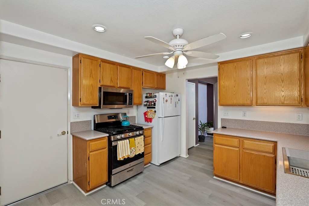 5509 Rodriguez Avenue Banning, CA 92220 - Photo 13 of 36 a kitchen with stainless steel appliances a stove top oven a refrigerator cabinets and wooden floor