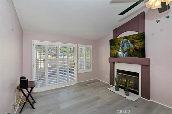 a view of an empty room with a fireplace and a window