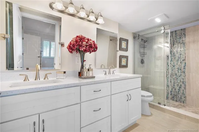 a bathroom with a double vanity sink mirror and shower