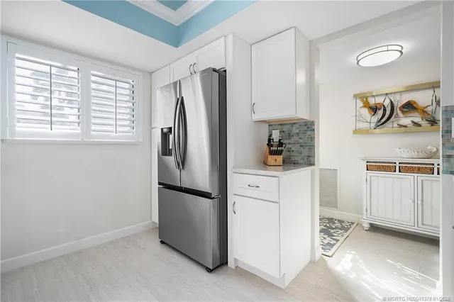 a kitchen with a refrigerator and white cabinets