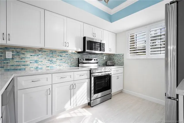 a kitchen with granite countertop white cabinets and stainless steel appliances