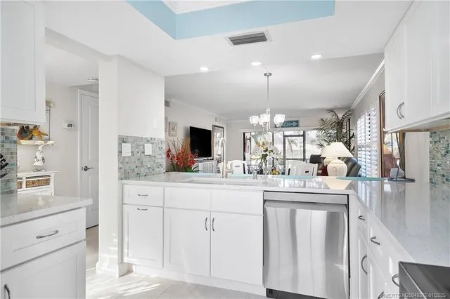 a kitchen with white cabinets and sink