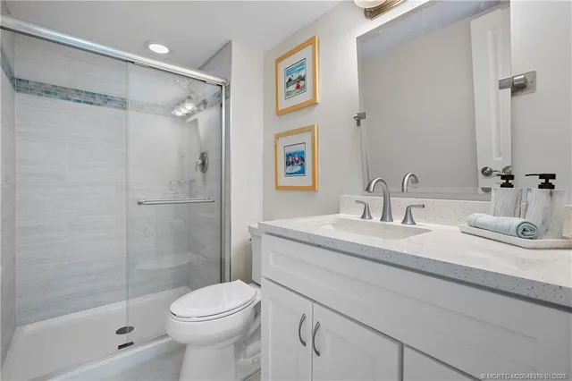 a bathroom with a granite countertop sink toilet and shower