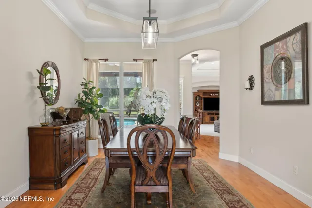 a kitchen with stainless steel appliances granite countertop a refrigerator a sink dishwasher a stove and white cabinets with wooden floor