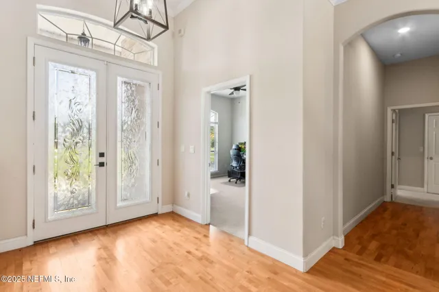 a dining room with furniture a chandelier and wooden floor