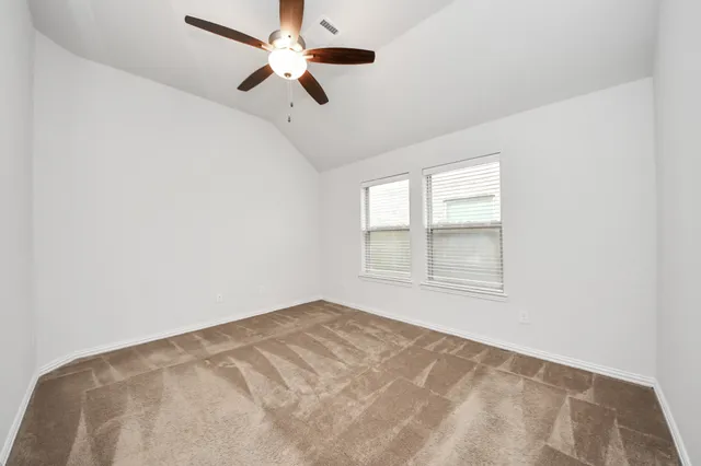 an empty room with a window and a fan