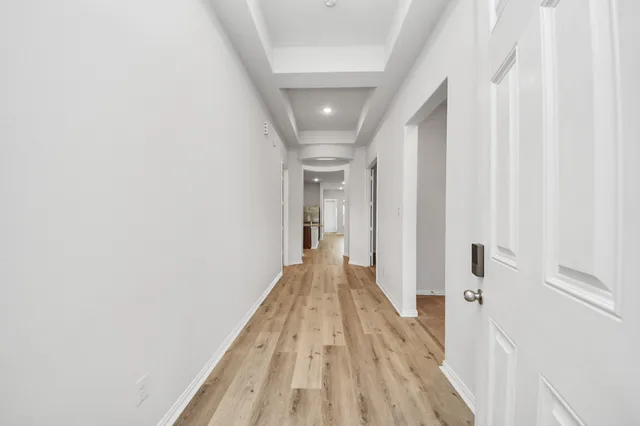 a view of a hallway with wooden floor and staircase