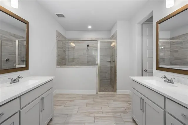 a bathroom with a sink double vanity and a mirror